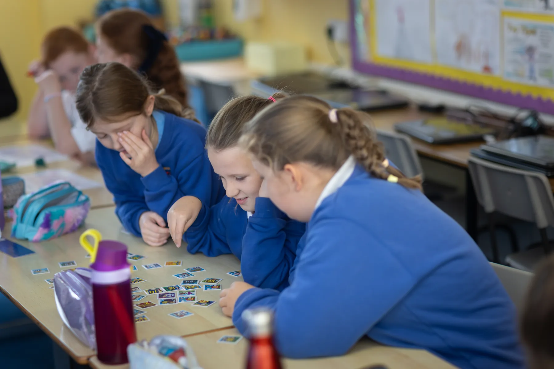 Pupils learning together around a classroom table